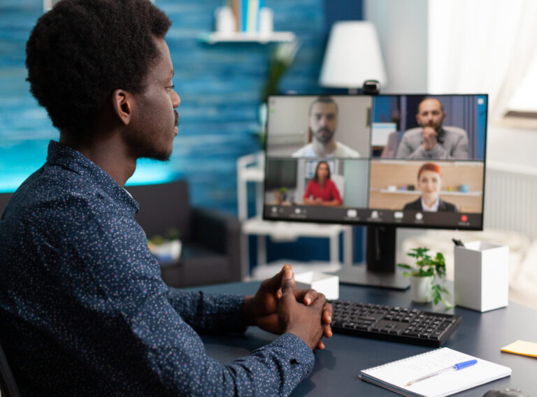 Man of african ethnicity using conference webcam communication to connect via internet with coworkers while working from home. Black person remote worker chatting about job duties